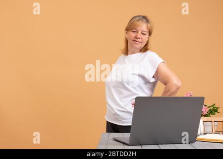 Concetto di stile di vita sano e professionale. Ritratto di una donna senior che fa esercizi sul posto di lavoro Foto Stock