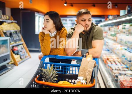 La coppia di famiglie annoiata nel negozio di alimentari Foto Stock