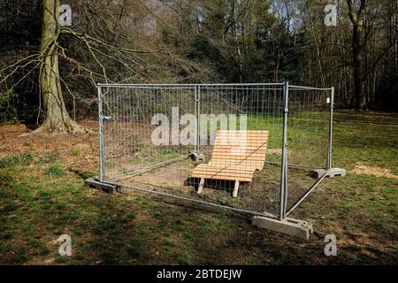 Duisburg, zona Ruhr, Nord Reno-Westfalia, Germania - Parco panca nella foresta della città di Duisburg recintato con recinzione in costruzione in tempi della corona Foto Stock