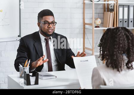 Candidato millenario che risponde alle domande del responsabile delle risorse umane durante il colloquio di lavoro in ufficio Foto Stock