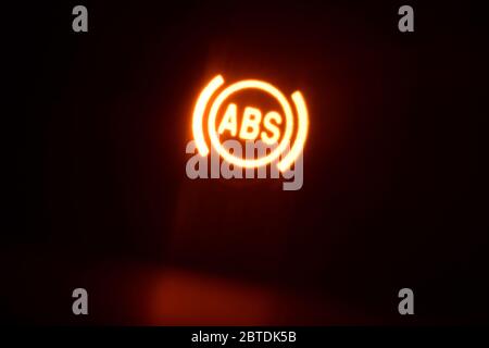 accensione della spia del cruscotto del sistema di frenata assistita (abs) sul veicolo durante la notte Foto Stock