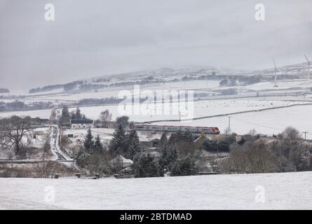 Virgin Trains classe 221 voyager train 221111 passando Crawick, Dumfries e Galloway, Scozia nella neve con un treno deviato Foto Stock