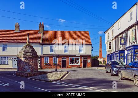 The Pump at Common Place, Little Walsingham, Norfolk, Regno Unito. La vecchia casa pompa villaggio per l'acqua di disegno circondato da case a graticcio Foto Stock