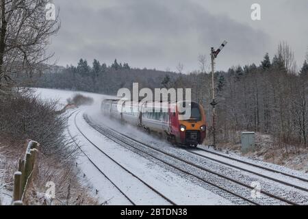 Un treno Virgin voyager passa per Thornhill (a nord di Dumfries) con un treno Glasgow Central - Carlisle, deviato a causa di un ponte danneggiato in neve pesante Foto Stock