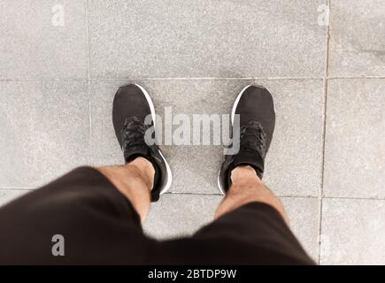 Corridore maschile guardando giù ai piedi della città Foto Stock