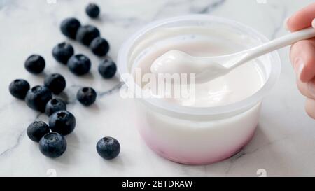 Mangiare yogurt greco. Yogurt greco puro in cucchiaio Foto Stock