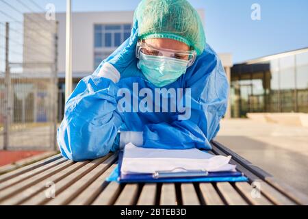 Personale infermieristico di fronte alla clinica che si occupa di valutare l'elenco di monitoraggio dei contatti durante la pandemia del coronavirus Foto Stock