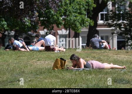 Hockley, Birmingham, 25 maggio 2020. Chi ama il sole potrà godersi il caldo tempo delle festività natalizie nei giardini della chiesa di St Paul nell'area di Hockley a Birmingham il lunedì pomeriggio. Le persone in cerca di sole si sono distanziate tra loro per mantenere gli orientamenti governativi durante la crisi COVID-19. Credito: Interrompi stampa Media/Alamy Live News Foto Stock