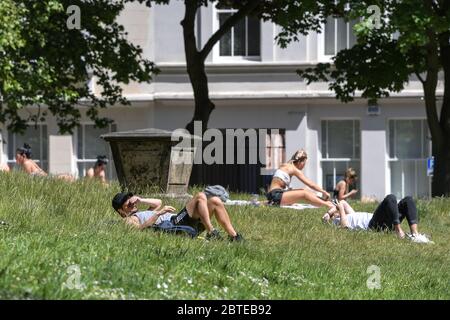 Hockley, Birmingham, 25 maggio 2020. Chi ama il sole potrà godersi il caldo tempo delle festività natalizie nei giardini della chiesa di St Paul nell'area di Hockley a Birmingham il lunedì pomeriggio. Le persone in cerca di sole si sono distanziate tra loro per mantenere gli orientamenti governativi durante la crisi COVID-19. Credito: Interrompi stampa Media/Alamy Live News Foto Stock