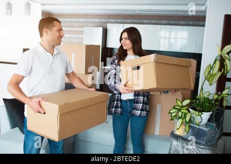 Giovane coppia che trasporta grande scatola di cartone a casa nuova home.moving Foto Stock