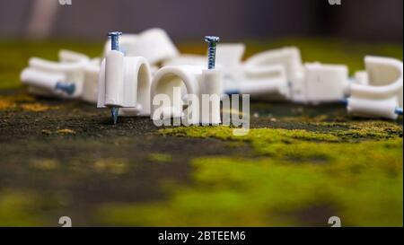 Primo piano di chiodi in ferro per il supporto del cavo sulla parete Foto Stock