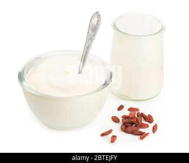 Yogurt in ciotole di vetro e frutti di bosco goji su sfondo bianco Foto Stock
