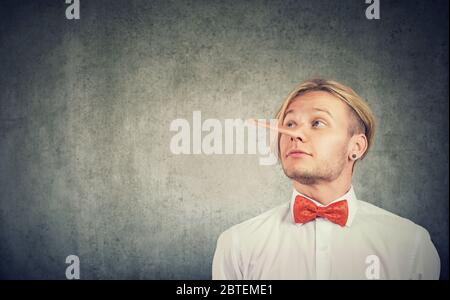 Un bugiardo divertente guardando l'uomo con il naso lungo Foto Stock