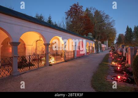 Zu Allerheiligen brennen unzählige Grablichter auf dem Friedhof in Teisendorf mit den umlaufenen Grüften unweit der Kirche St. Andreas Foto Stock