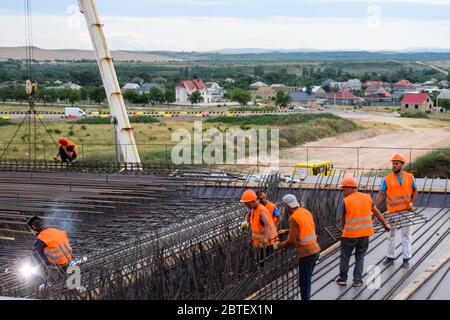 Costruzione di un nuovo interscambio stradale e di trasporto. Lavori su strutture in cemento armato e superficie stradale. Foto Stock