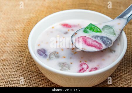 Farina bollita nel latte di cocco con condimento al sesamo (Krong Krang), dessert tradizionale tailandese. Foto Stock