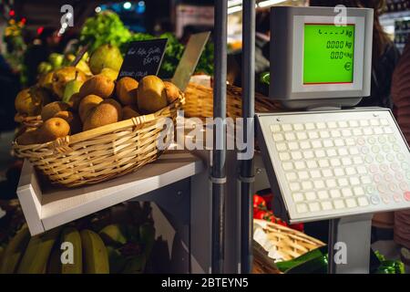 Frutta fresca e gustosa in uno stand di mercato in italia, con scala di peso e etichetta di prezzo che significa kiwi polpa gialla; origine: italia Foto Stock