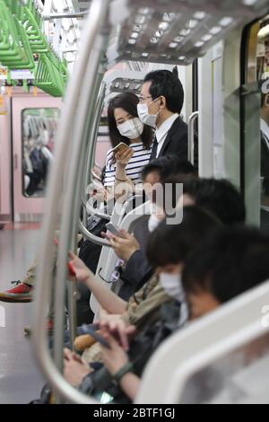 Tokyo, Giappone. 25 Maggio 2020. Le persone che indossano maschere facciali prendono un treno a Tokyo, Giappone, il 25 maggio 2020. Lunedì il primo ministro giapponese Shinzo Abe ha revocato lo stato di emergenza COVID-19 nelle cinque prefetture rimanenti ancora soggette a restrizioni, tra cui Tokyo, poiché la diffusione del virus è stata in gran parte controllata. Credit: Du Xiaoyi/Xinhua/Alamy Live News Foto Stock