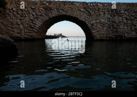 Europa, Portogallo, Caiscas. Un uomo nuota al centro del ponte che delimita il Palácio dos Condes de Castro Guimarães a Caiscas. Foto Stock