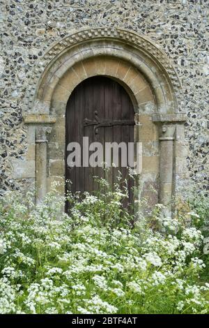 Porta in stile normanno sul lato della vecchia chiesa di Burghclere con prezzemolo di mucca in primo piano, Old Burghclere, Hampshire, Inghilterra, Regno Unito, Europa Foto Stock