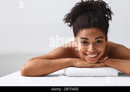 Primo piano di bella ragazza nera che giace sul tavolo di massaggio Foto Stock