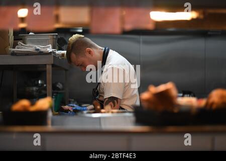 Lo chef Stuart McAlney serve cene take away arrosto al pub Crabtree di Fulham, Londra, dopo l'introduzione di misure per portare il paese fuori dalla serratura. Foto Stock