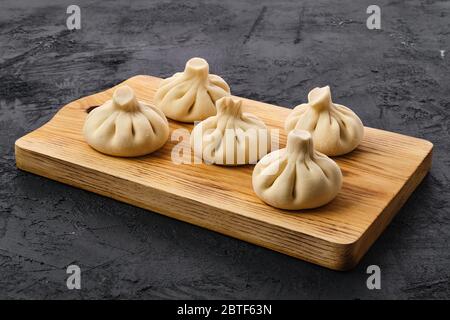 Khinkali non cotti su tavola di legno Foto Stock