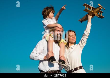 Famiglia madre padre e figlio sognano di viaggiare. Concetto di vacanza estiva e vacanza. Figlio che abbruttava i genitori sulla natura. Famiglia che viaggia con bambino Foto Stock