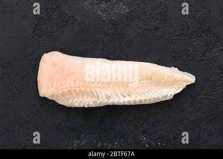 Filetto di nasello crudo poco profondo su fondo nero Foto Stock