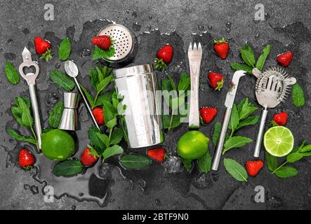 Accessori da bar e ingredienti per cocktail di fragole, lime, menta, ghiaccio Foto Stock