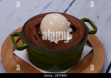 torta fondente al cioccolato al forno con gelato alla vanila in una ciotola di metallo Foto Stock