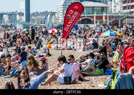 Brighton, Regno Unito. 25 Maggio 2020. E' soleggiata e la gente viene in spiaggia e sul mare a Brighton, durante le vacanze di Lunedi'. È occupato ma ancora plentyu di spazio per la distanza sociale. Il "blocco" dei morti continua per l'epidemia di Coronavirus (Covid 19). Credit: Guy Bell/Alamy Live News Foto Stock