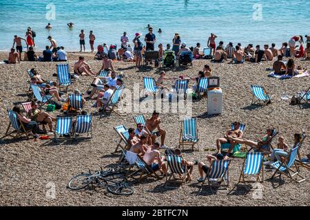 Brighton, Regno Unito. 25 Maggio 2020. E' soleggiata e la gente viene in spiaggia e sul mare a Brighton, durante le vacanze di Lunedi'. È occupato ma ancora plentyu di spazio per la distanza sociale. Il "blocco" dei morti continua per l'epidemia di Coronavirus (Covid 19). Credit: Guy Bell/Alamy Live News Foto Stock