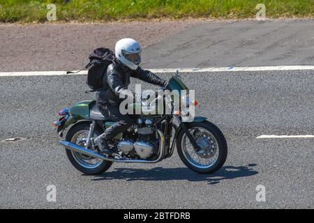 Pilota di Triumph Motorbike a due cilindri verde; due ruote di trasporto, moto, veicolo, strade, moto, motociclisti che si motorano sull'autostrada M6 Chorley, Regno Unito Foto Stock