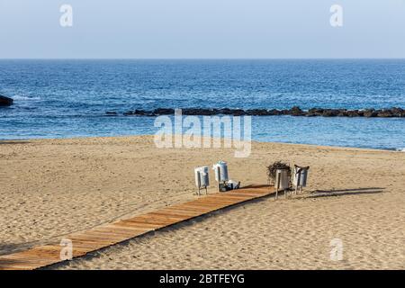 Bidoni spazzatura pieni di rifiuti alla fine di un passaggio in legno sulla spiaggia di Playa del Duque il primo giorno della fase due di de-escalation, Covid19, Coronavi Foto Stock