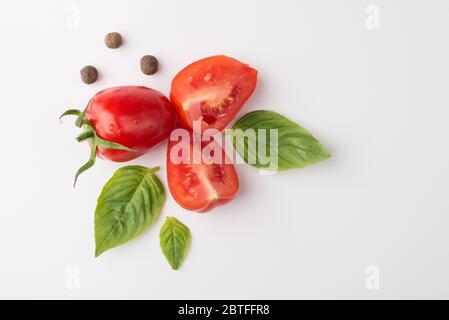 Concetto di cibo biologico. In alto, vista dall'alto, foto di pomodori spezie e spinaci isolati su sfondo bianco Foto Stock