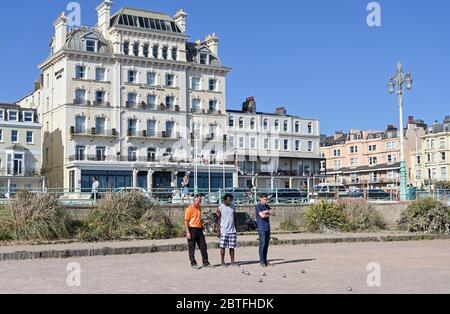 Brighton UK 25 maggio 2020 - tempo per un dolce gioco di bocce nel tardo pomeriggio sole sul lungomare di Brighton, come il fine settimana di festa della banca si avvicina a un termine oggi sulla costa meridionale durante la crisi pandemica di Coronavirus COVID-19 . Credit: Simon Dack / Alamy Live News Foto Stock