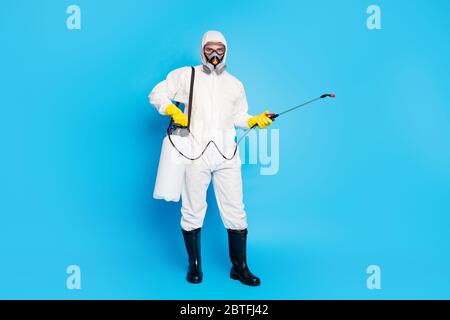 Foto a dimensione intera del medico uomo in Hazmat indossare l'attrezzatura fermare il covid19 epidemia infezione diffusione isolata su sfondo blu Foto Stock