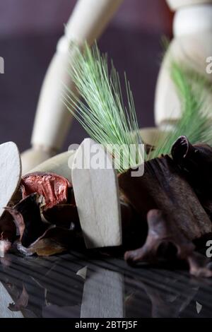 stalco di cereali freschi sulle gambe di una bambola di legno, con molti frutti di primavera secchi Foto Stock