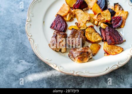 Bistecca di agnello con fette di barbabietola e patate al forno arrosto / Lokum turco Kuzu o delizia servita con piatto. Piatto di carne biologico. Foto Stock