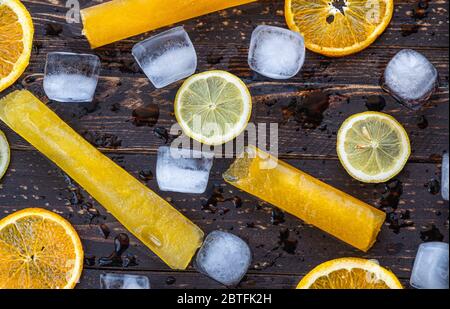 Primo piano di lecci di frutta, fette di limone e arancia e cubetti di ghiaccio Foto Stock