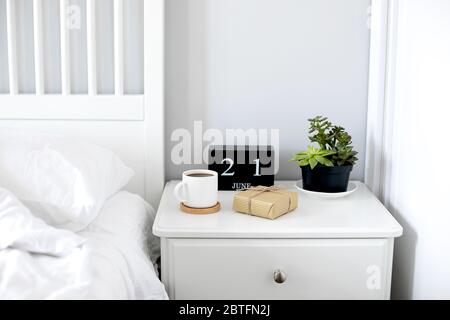 Tazza di caffè, omaggio, quotidiano, bicchieri e bowtie al mattino sulla scrivania in legno per la colazione l'Happy Feathers Day Foto Stock