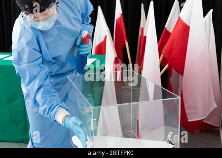 Dipendente che indossa un vestito speciale. Disinfezione di tutte le superfici. Elezioni presidenziali. Foto Stock