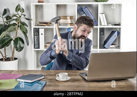 Emozioni umane. Virus del ritardo del computer. Uomo d'affari arrabbiato o manager con il martello. Uomo d'affari aggressivo in ufficio. Motivi per il ritardo del computer. Odiate la routine dell'ufficio. Risolvi alcuni problemi aziendali. Foto Stock