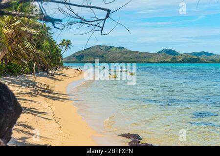 Costa di un'isola tropicale, spiaggia e acqua cristallina. Isole e baie in lontananza Foto Stock