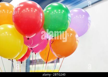 Palloncini di elio con nastri in ufficio. Sfondo colorato festivo per la celebrazione del compleanno, festa aziendale, anniversario, festa dei bambini Foto Stock