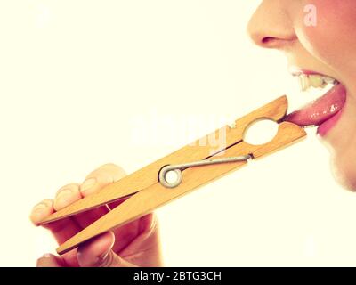 Barriera linguistica, indiscrezioni, problemi con esprimenti il concetto. Donna bionda con linguetta in clothespin Foto Stock