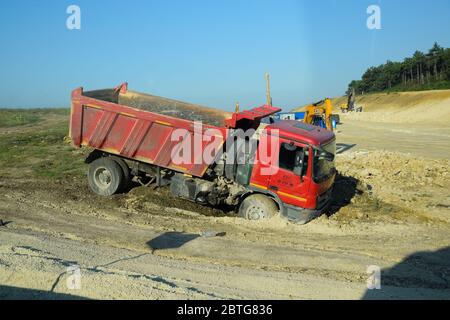 Taman, Russia - 9 giugno 2019: Un camion di scarico kamaz è rimasto bloccato nel fango sul lato della strada. Foto Stock