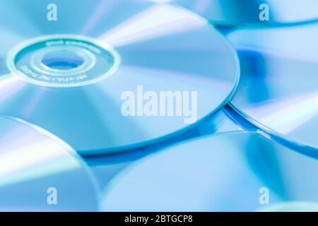 Pila di CD o DVD in blu come sfondo. Messa a fuoco morbida. Foto Stock