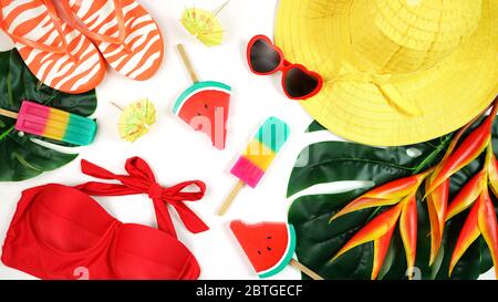 Resort vacanze estive a tema con cappello, gelati, costume da bagno, occhiali da sole, foglie tropicali e fiori in colori luminosi. Moderno ed elegante Foto Stock
